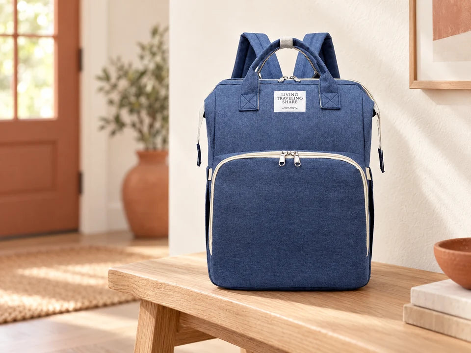 Mochila azul escura com bolso frontal e pegas, apresentada num banco de madeira
